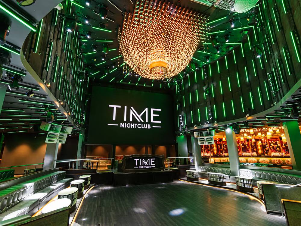 Interior of Time Nightclub, green lighting and a large chandelier over the main floor.